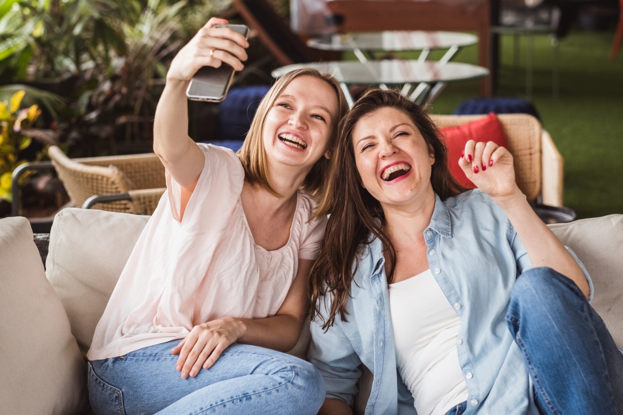 Two girls take photo for social media accounts